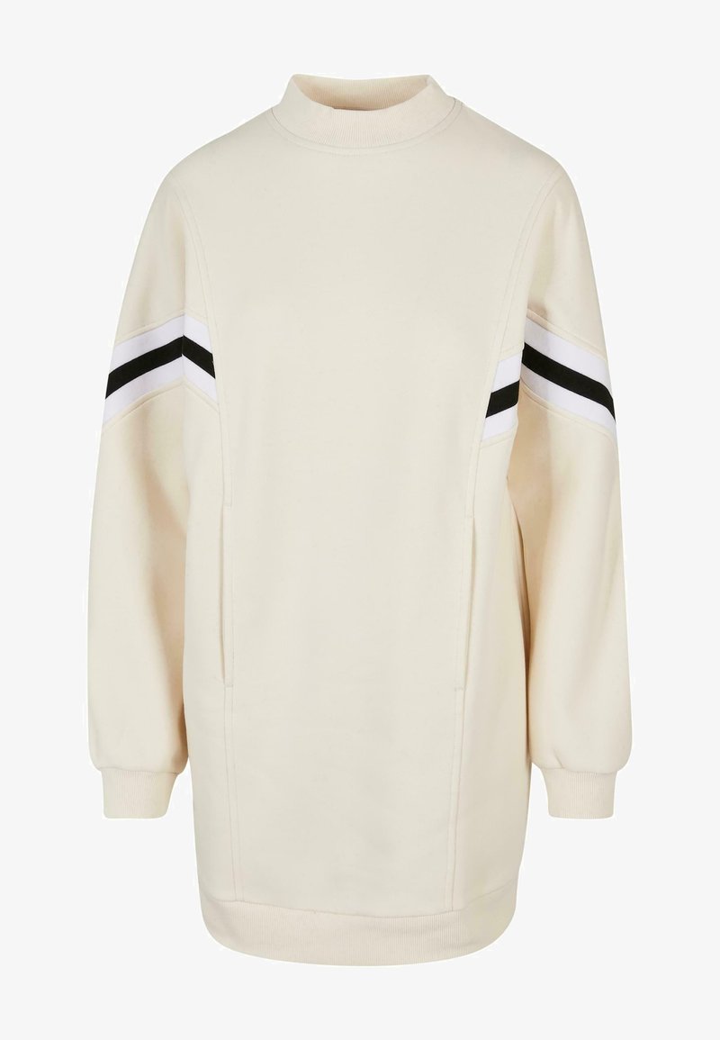 Kreemikampsun kõrge kaelusega, pikkade varrukatega ja kahe küljetaskuga. Õlgadel on must-valged triibud. Pehme, tekstuuriga kangas.