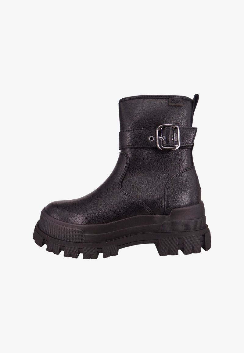 Bottine noire en cuir avec semelle à crampons épaisse et détail de bride à boucle argentée sur le côté.