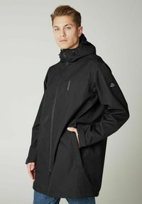 Schwarze wasserfeste Jacke mit durchgehendem Reißverschluss, verstellbarem Kapuze, zwei Seitentaschen und Logo-Details auf der Schulter und der Brust.