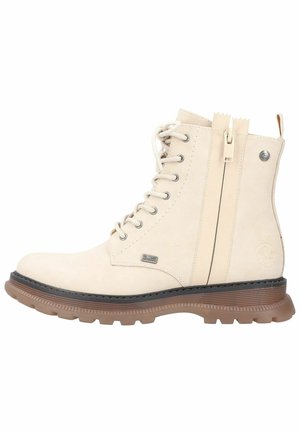 Bottine en dentelle beige clair avec fermeture éclair sur le côté, semelle en caoutchouc épaisse marron et petites plaques métalliques de marque sur le côté.