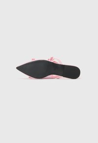 Chaussure rose à bout pointu avec un dessus lisse et des liens décoratifs, dotée d'une semelle en caoutchouc noir avec une texture antidérapante pour une meilleure adhérence.