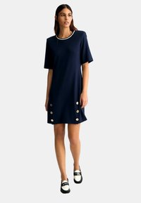 Abito navy a maniche corte con scollatura rotonda, caratterizzato da bottoni dorati ai lati e una texture di tessuto liscia.