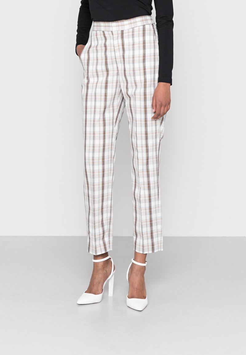 Kostkované kalhoty s bílým podkladem a hnědými pruhy, se zvýšeným pasem, postranními kapsami a tvarovanou nohavicí. V páru s bílými podpatky.