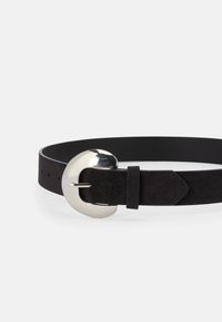 Curea din suede negru cu o cataramă metalică circulară și o curea ajustabilă cu mai multe găuri pentru o potrivire perfectă. Textură netedă cu un design elegant.