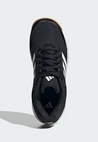 Chaussure de sport noire avec une tige en mesh, motif à trois bandes blanches et semelle noire texturée. Comprend des lacets noirs et un col rembourré.