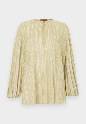 Jasnożółta bluzka z pionowymi metalicznymi paskami, delikatnym dekoltem w kształcie litery V i długimi bufiastymi rękawami. Miękka faktura z połyskującymi akcentami.