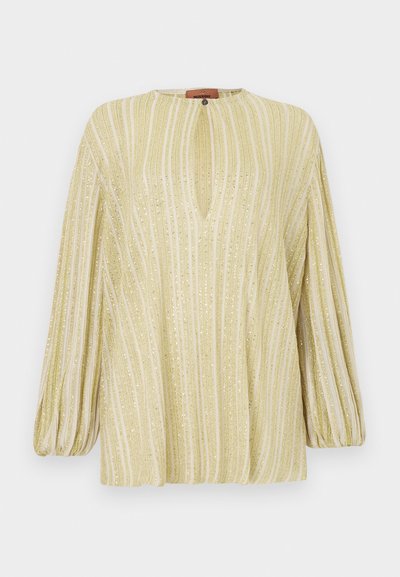 Lysegul bluse med lodrette metalliske striber, en diskret V-hals og lange ballonærmer. Blød tekstur med skinnende detaljer.