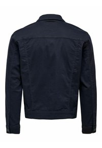 Giacca in cotone blu navy, con taglio dritto, colletto classico e polsini con bottoni. Texture liscia con dettagli di cucitura minimal.
