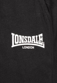 Zwarte katoenen stof met witte "LONSDALE LONDON" tekstlogo, met een vet, gebogen ontwerp en een gladde textuur.