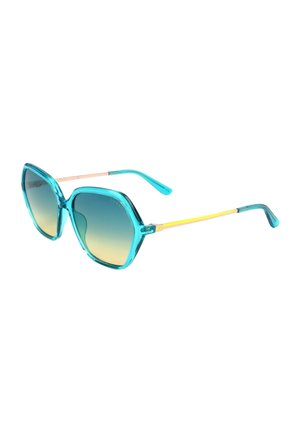 Occhiali da sole esagonali oversize blu con lenti dégradé e sottili aste dorate su sfondo bianco.