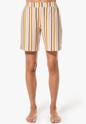 Bara Beine mit kniehohen Shorts mit vertikalen Streifen in Senf, Rosa, Weiß und Taupe vor einfachem Hintergrund.