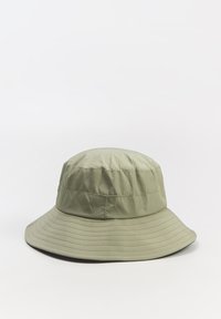 Zielona kapelusz typu bucket wykonana z lekkiego materiału o gładkiej fakturze, z szerokim rondem i przeszyciem wokół korony oraz krawędzi.