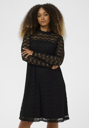 Black lace dress with long sleeves, wavy pattern, and a knee-length design. Features a round neckline and semi-sheer texture.