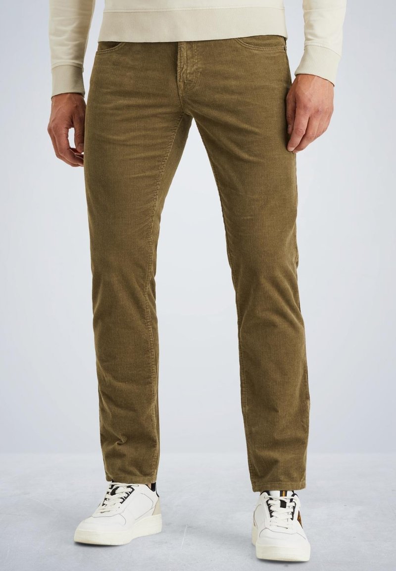 Pantaloni di velluto a coste verde oliva con taglio dritto, dotati di cinque tasche e una texture morbida, abbinati a sneakers bianche.