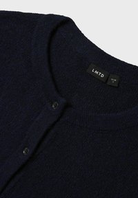 Marineblaue gestrickte Strickjacke mit strukturierter Oberfläche, runder Halsauschnitt, Knopfleiste und einem Etikett mit der Aufschrift "LMTD" und Größe "S".