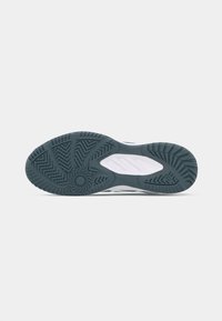 Shoe outsole featuring a wave pattern in dark teal and gray rubber, textured for grip, with a circular design at the heel area.