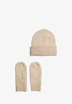 Bonnet beige tricoté avec un revers plié, assorti de deux mitaines sans doigts. Texture douce, design simple et détails côtelés.