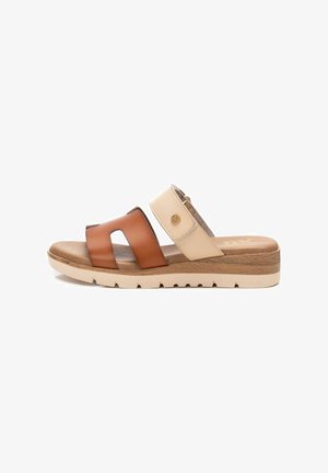 Sandaalia deslizante marrón y beige con dos correas anchas, cuero texturizado y suela de cuña. Presenta un acento de logo y colores contrastantes.
