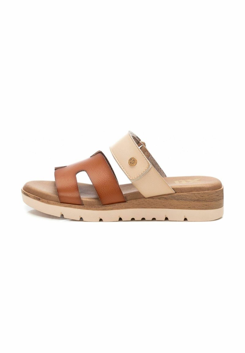 Sandaalia deslizante marrón y beige con dos correas anchas, cuero texturizado y suela de cuña. Presenta un acento de logo y colores contrastantes.