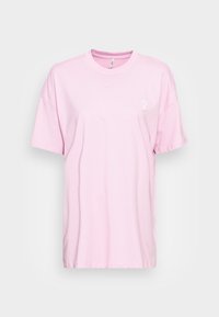 T-shirt di cotone rosa con collo rotondo, maniche corte e un piccolo simbolo femminile bianco stampato sulla parte sinistra del petto.