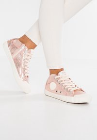 Růžové tenisky s metalickým a semišovým povrchem, šněrováním, zipy a strukturovanou gumovou podrážkou s kulatým logem.