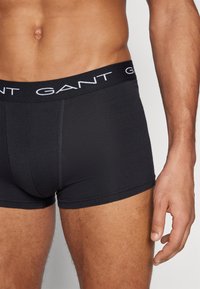 Mustad puuvillased bokserid, millel on istuv disain ja kontrastne valge "GANT" logo elastne vöökoht. Sile tekstuur ja minimaalsed õmblused.