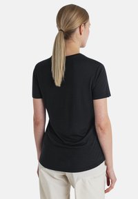 Black short-sleeve t-shirt with a round neckline, made of smooth fabric, fitted shape, and a slight curvature at the hem.