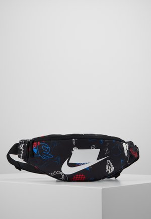 Sac banane noir Nike avec grand logo swoosh blanc et motifs abstraits colorés bleu et rouge, présenté sur un piédestal blanc sur fond gris.