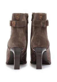 Ruske nubuk ankle boots med teksturert, metallisk detalj, med glidelås og kraftig hæl. Justerbar stroppdetalj ved ankelen.
