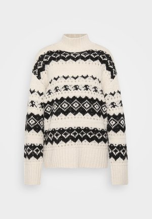 Suéter crema con cuello alto, patrones geométricos negros y puños y dobladillo acanalados. Textura de punto suave, corte oversized.