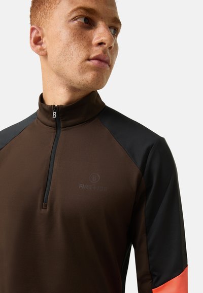 Brown zip-up athletic top with black shoulder panels and orange accents. Features a high collar and a subtle logo on the front. Smooth texture.