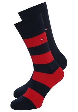 Chaussettes rayées dans des couleurs rouge et bleu marine foncé, fabriquées à partir d'un matériau doux, avec un motif horizontal et un accent logo.