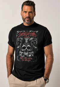 Sort t-shirt med korte ærmer, der har et grafisk design med et kranium, horn og slanger. Teksten lyder "Lev med det forkerte, lev med ild."