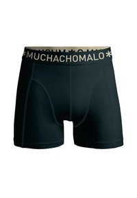 Fekete boxer alsónemű sima anyagból, kontrasztos bézs derékpánttal, amelyen a "MUCHACHO" felirat ismétlődő mintában szerepel.