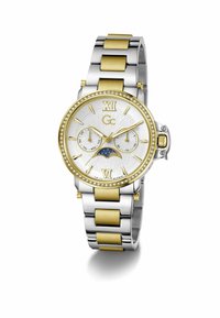 Montre-bracelet bicolore argent et or avec cadran blanc, chiffres romains, sous-cadrans pour le jour et la date, indicateur de phase lunaire, et lunette incrustée de cristaux.