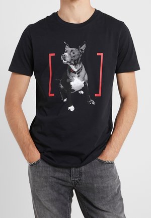 Black cotton t-shirt featuring a graphic of a sitting dog in grayscale with a red-bordered background, crew neck, and short sleeves.
