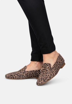 Leopard print flat shoes with a suede texture, featuring a gold hardware accent and a low profile design. Paired with black pants.