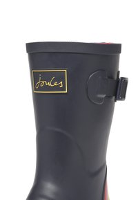Marinblå gummistövlar för regn med texturerad yta, guld Joules-logotyp på svart etikett, justerbar sidspänne och en kontrasterande färgglad innerfoder.
