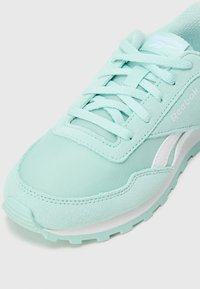 Světlězelené tenisky Reebok s hladkým textilním svrškem, strukturovanými bočními panely a bílými akcenty. Obsahují tkaničkový design a polstrovanou podešev.