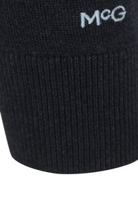 Navy gebreide sweater met ribbelstructuur en een blauw geborduurd logo "McG" aan de zijkant.