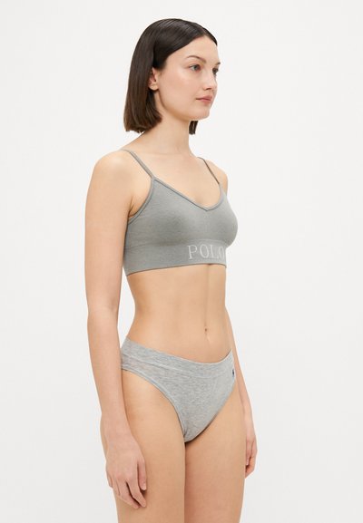 Pelēkā ribota bralette ar plānām siksnām un "POLO" logo; apvienots ar atbilstošām pelēkām hipster biksītēm, kurām ir mīksts jostasvieds.