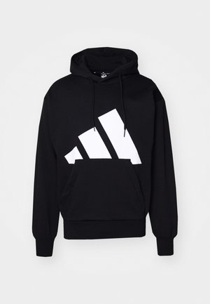 Mustmustri must musta suur valge adidas'i logo, reguleeritav paelaga kapuuts, ees kangaroo-tasku, soonikkoes varrukad ja alumine äär. Puuvillane materjal.