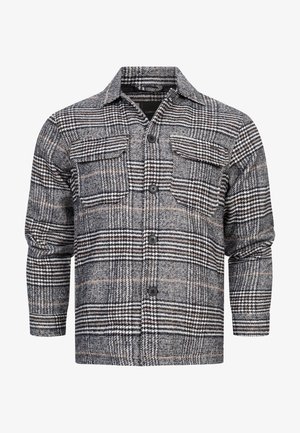 Rutet flanellskjorte i svart, hvit og brunnyanser. Har to brystlommer, knappelukking og lange ermer med rynkede mansjetter.