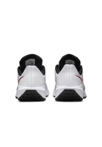 O pereche de pantofi atletici albi cu tălpi și căptușeală interioară negre, priviți din spate, având accente roșii Nike swoosh pe fiecare latură.