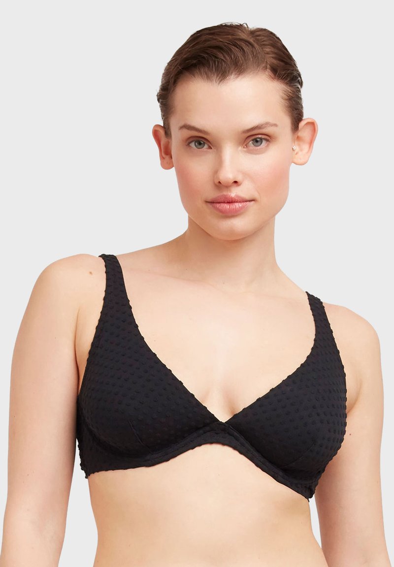 Bralette a triangolo nero in tessuto testurizzato, con spalline larghe e una finitura liscia. Presenta un sottoseno di supporto e un design minimalista.