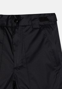 Crne hlače od glatkog, sjajnog materijala, s kopčanjem na dugme i čičak detaljem na pojasu, s uredno ušivenim plisama.