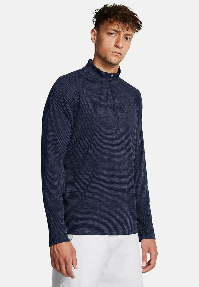 Marineblauw langetermijnpullover met een halflange ritskraag, textuurpatroon en getailleerd ontwerp. Bevat subtiele logodetails op de borst.