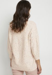 Maglione lavorato a maglia di un rosa chiaro con una finitura texturizzata, caratterizzato da macchie multicolori, maniche a tre quarti e un fit ampio. Orlo a costine.