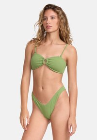 Set di bikini verde con finitura testurizzata. Il top presenta un dettaglio con nodo centrale; il fondo ha aperture alte sui lati e una vita a forma di V.