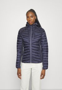 Marine pufferjack met een capuchon, voorzien van een gequilte ontwerp, vooraan met een rits en een merklogo op de borst. Soepele textuur en getailleerde pasvorm.